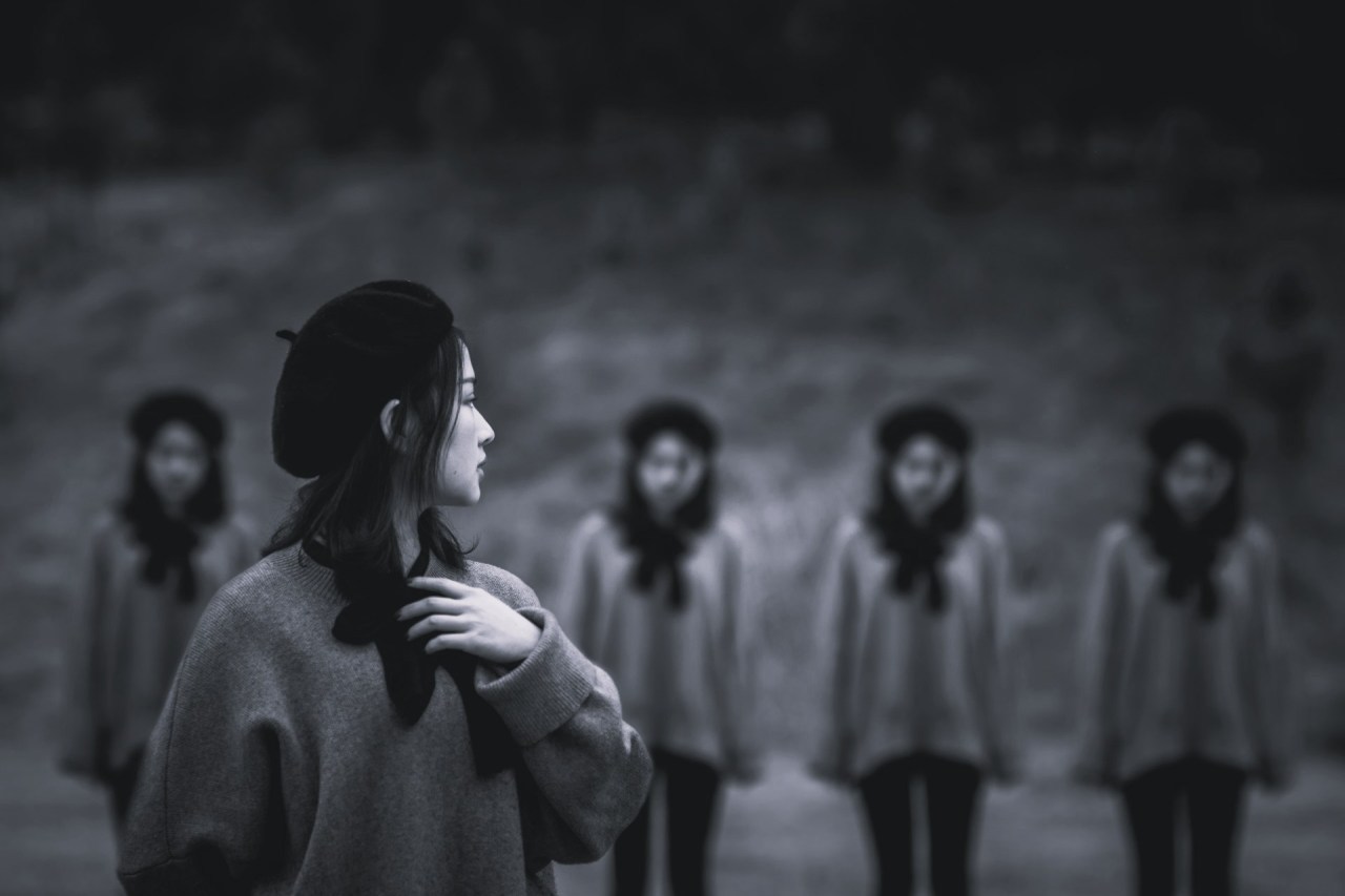 Woman standing apart from a group of people, representing the difference between what feels familiar and what is right for us.