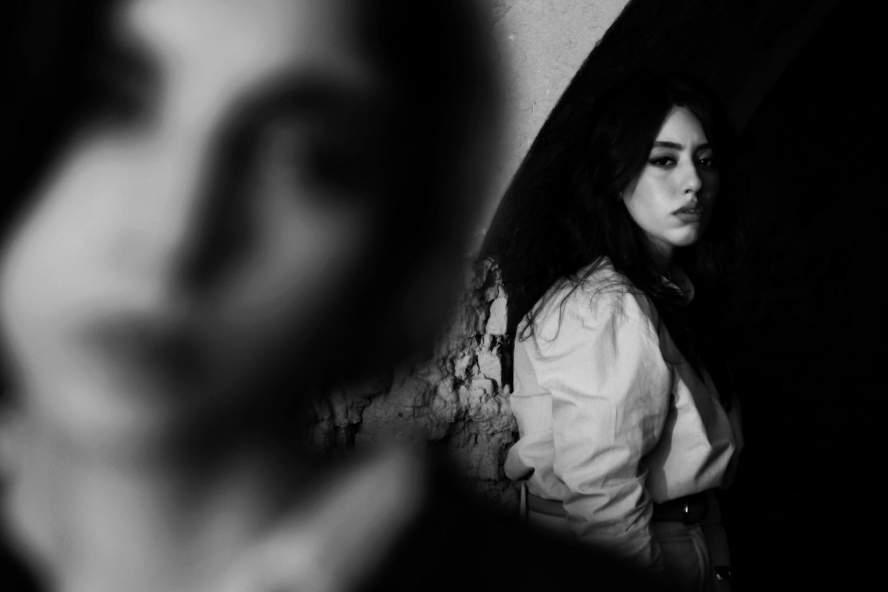Woman looking at her reflection, representing the courage to confront difficult truths