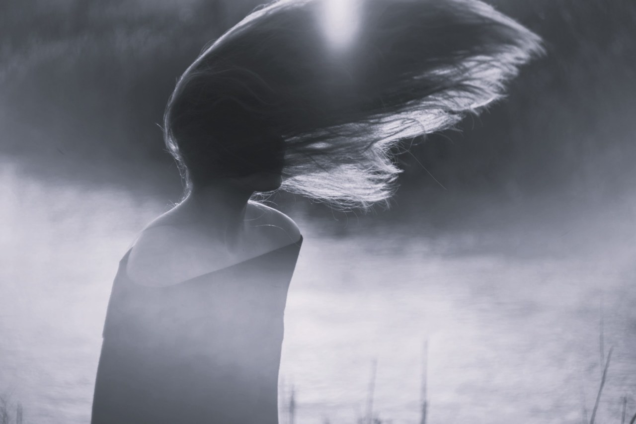Black and white image of a woman in profile with her head lowered, representing personal growth, changing relationships, and outgrowing old dynamics.