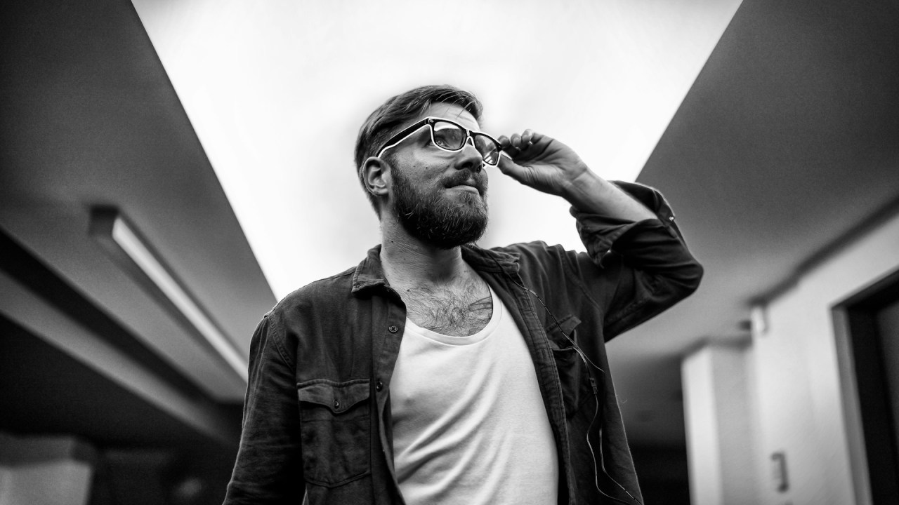 Man standing outdoors with his hand on his head, reflecting uncertainty and the confidence it can take to reconsider a decision.