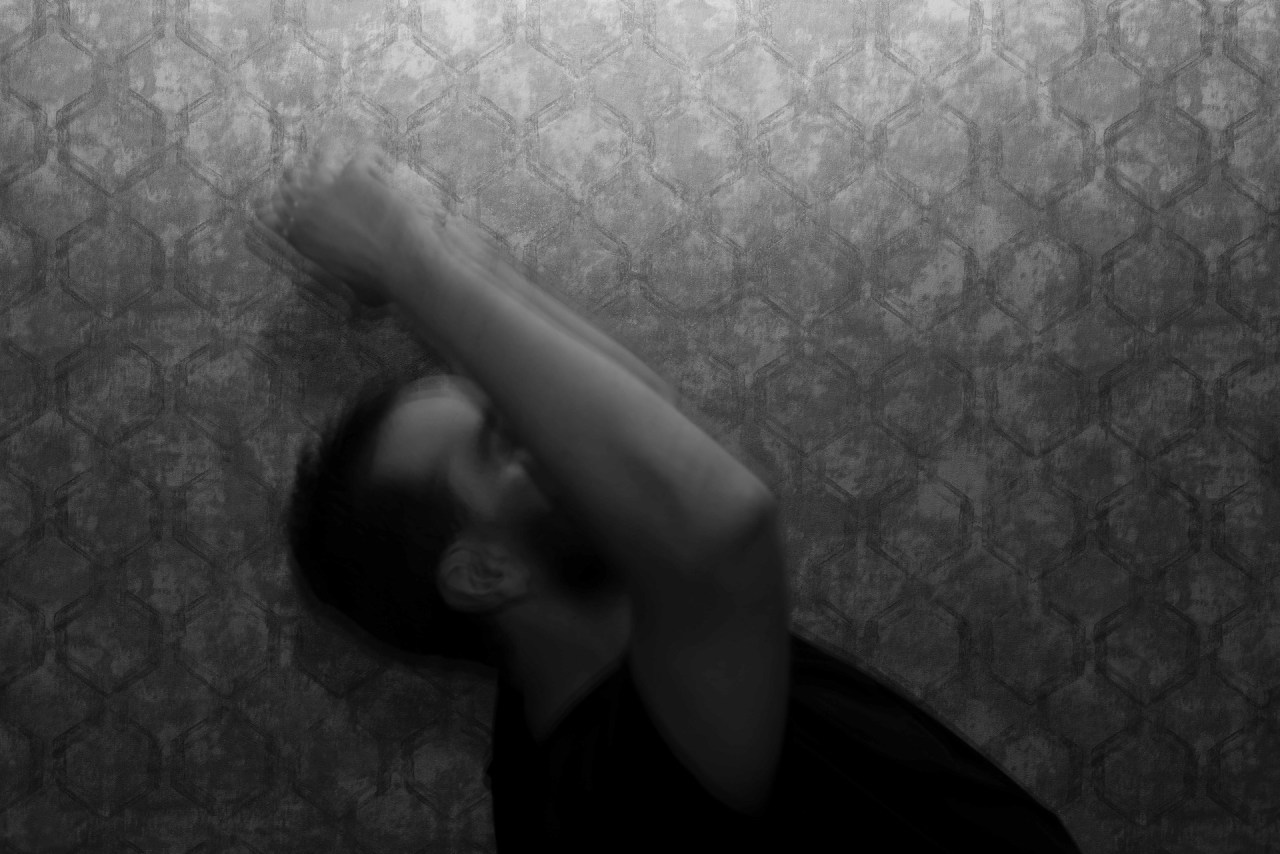 Black and white image of a woman sitting alone with her head lowered, representing difficult moments, self-compassion, and staying on your own side.