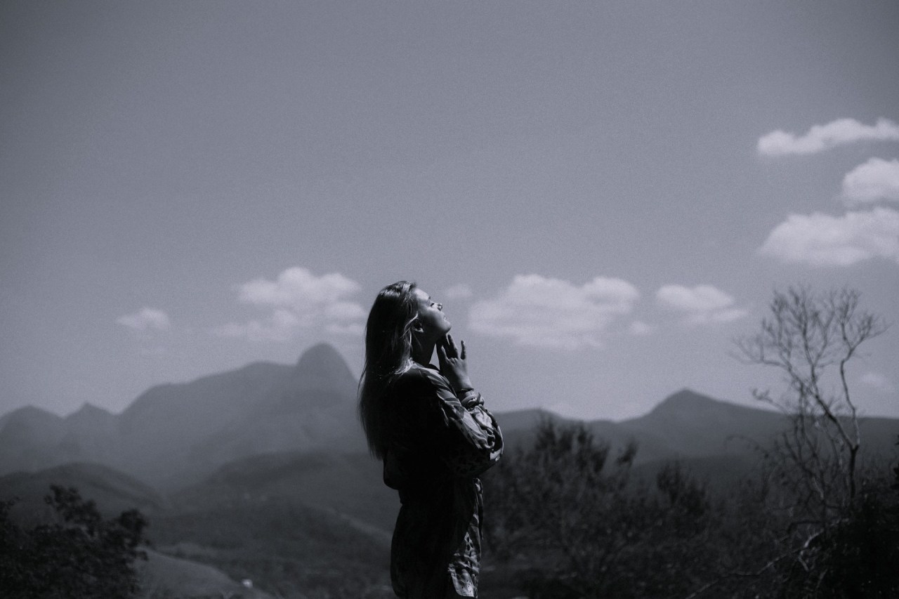 Woman standing alone in a misty mountain landscape, reflecting on accepting weaknesses and personal limitations